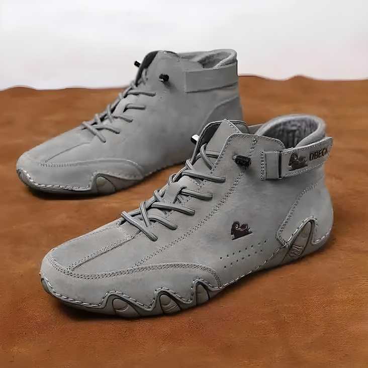 Gray high-top sneakers on a brown surface with a white background